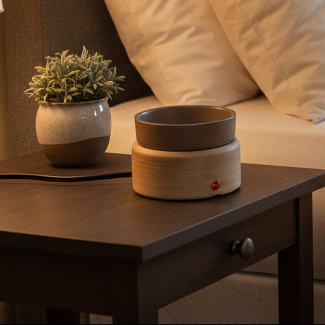 Mocha wax melter sitting on a table next to a bed. 